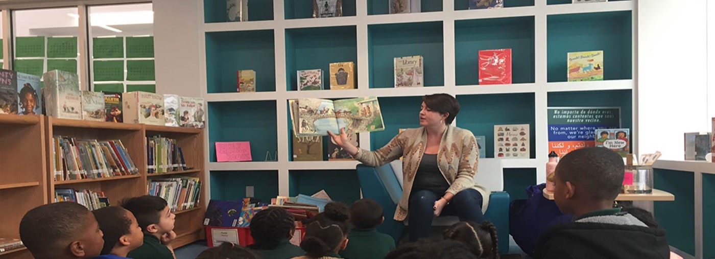 A teacher reading with students in the school library